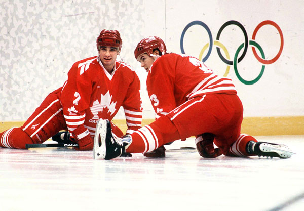 Canada's Todd Hlushko (left) and Adrian Aucoin participate in hockey action at the 1994 Winter Olympics in Lillehammer. (CP Photo/COA/Claus Andersen)