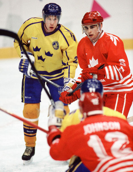 Canada's Ken Lovsin (right) competes in hockey action against Sweden at the 1994 Winter Olympics in Lillehammer. (CP Photo/COA/Claus Andersen)