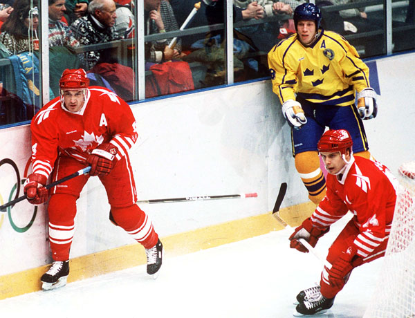 Canada's Derek Mayer and Brad Schlegel (red) compete in hockey action at the 1994 Winter Olympics in Lillehammer. (CP Photo/COA/Claus Andersen)
