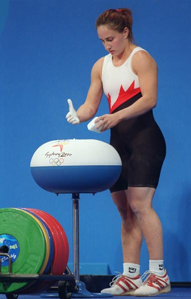 Canada's Maryse Turcotte chalks her hands during the women's 58 kg weightlifting competition at the Sydney Olympic Games on Monday September 18, 2000. (CP Photo/COA)