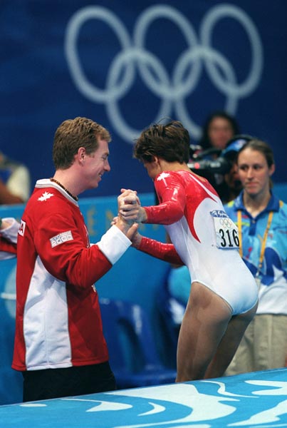 Canada's Yvonne Tousek gets a hand from her  coach at the 2000 Sydney Olympic Games. (CP Photo/ COA)