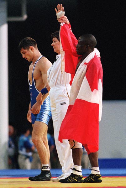 Canada's Daniel Igali has his hand raised as the victor over his wrestling opponent Arsen Gitinov at the 2000 Sydney Olympic Games. (CP Photo/ COA)