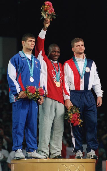 Canada's Daniel Igali stands on the winners podium with Arsen Gitinov; Silver, and Licoln McIlvray; Bronze. Igali won the gold at the 2000 Sydney Olympic Games. (CP Photo/ COA)