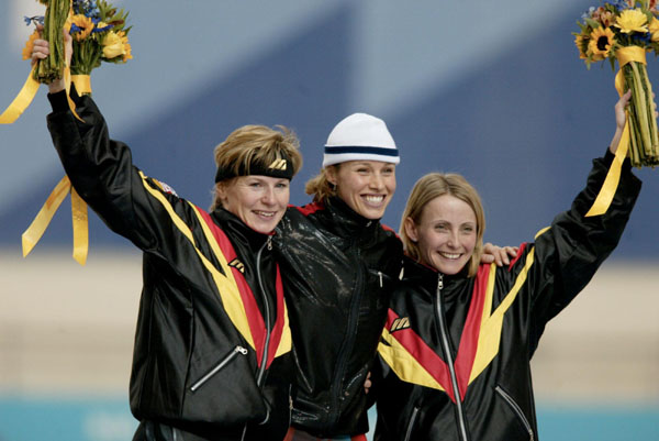 Catriona Le May Doan (centre) of Saskatoon celebrates her gold medal run in the women's 500 metre speed skating event with silver medallist Monique Garbrecht-Enfeldt and bronze medal winner Sabine Voelker (right), both of Germany at the Winter Olympics in