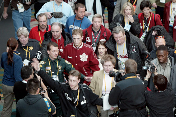 Canadian pairs skaters David Pelletier (red jacket,centre) and Jamie Sale make their way through a crowd of media after the announcement that the pair would be given a gold medal at the Winter Olympics in Salt Lake City, Fri., Feb. 15, 2002.  (CP PHOTO/CO