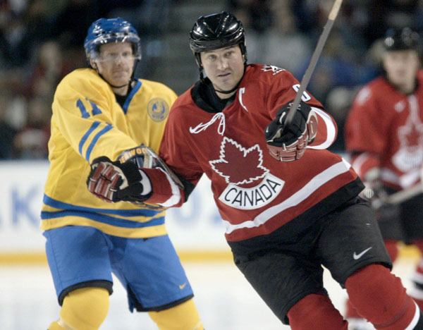 Canada's Mario Lemieux tries to escape the reach of Sweden's Daniel Alfredsson (11) during a 5 - 2 Swedish win in men's hockey action at the Winter Olympics in Salt Lake City, Fri., Feb. 15, 2002.  (CP PHOTO/COA/Mike Ridewood)