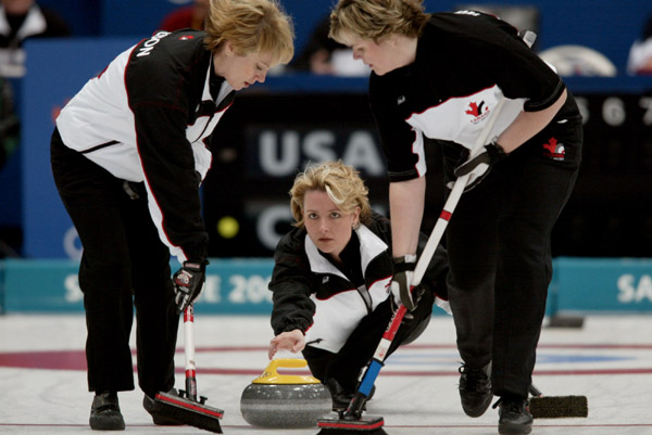 La capitaine canadienne Kelley Law effectue un lancer tandis que les balayeuses Diane Nelson ( droite) et Georgina Wheatcroft prennent position au cours du tournoi de curling comptant pour la mdaille de bronze, remporte par le Canada avec un score de 9