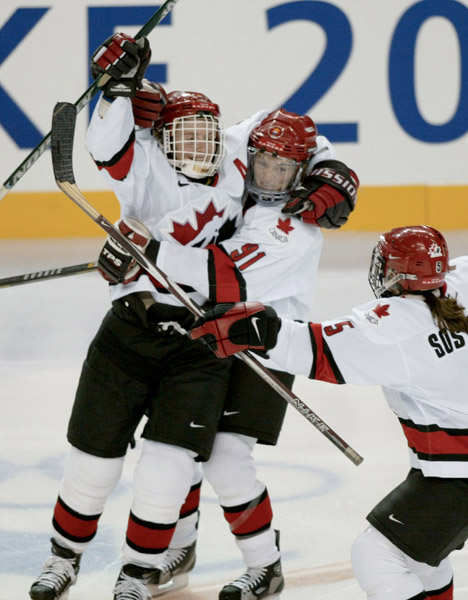 Hayley Wickenheiser (left) celebrates her second period goal with teammates Geraldine Heaney (91) and Colleen Sostorics.  Canada won the gold medal with at 3 - 2 victory over the United States in Salt Lake City , Utah during the Winter Olympics, Thursday,