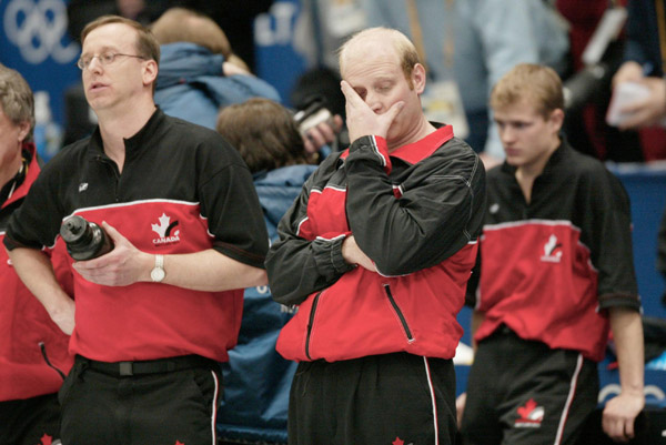 Canadian men's curling skip Kevin Martin (centre), of Edmonton, second Carter Rycroft (right), of Grand Prairie, Alta., and lead Don Bartlett, of Spruce Grove, Alta., show their disappointment after losing 6 - 5 in the gold medal game against Norway durin