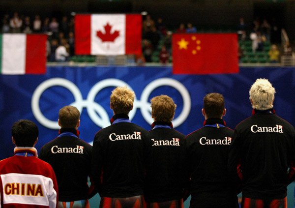 Canadian Short Track Gold medallists (left to right) Mathieu Turcotte, Jonathan Guilmette, Francois-Louis Tremblay and Marc Gagnon stand side by side as the Canadian flag goes up after winning gold in the Men's 5000 metre Relay Saturday Feb. 23, 2002 at t