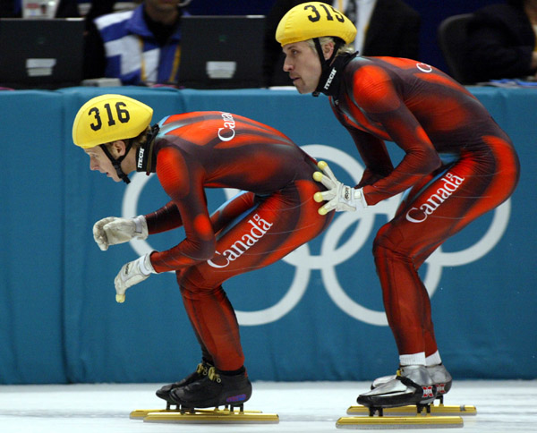 Canadian Short Track Gold skater Marc Gagnon gives a push to teammate Jonathan Guilmette during the  Men's 5000 metre Relay Saturday Feb. 23, 2002 at the 2002 Winter Olympic Games in Salt Lake City.  The Canadians went on to win gold. (CP Photo/COA/Andre