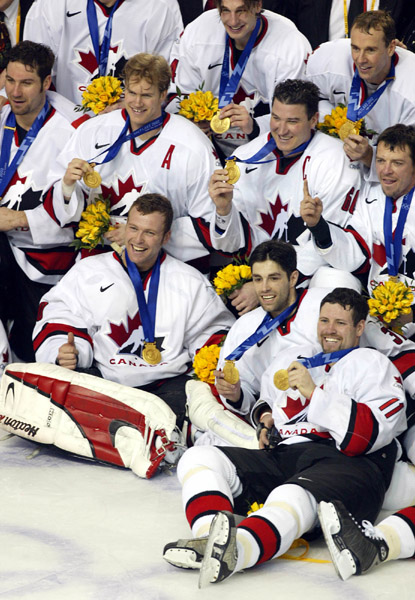 Team Canada captain Mario Lemieux and goalie Martin Brodeur are surrounded by teammates as they pose for a team photo after they won over Team USA to win the gold medal in hockey Sunday Feb. 24, 2002 at the 2002 Winter Olympic Games in Salt Lake City. Tea