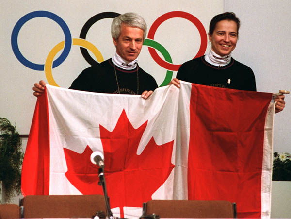 Sylvie Daigle et Walter Sieber du Canada soulvent le drapeau du Canada aux Jeux olympiques d'hiver d'Albertville de 1992. (Photo PC/AOC)