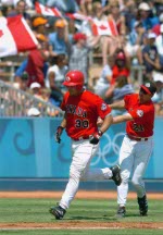 Canadian Pete Laforest is congratulated by third base coach Tim Leiper after hitting a three-run homer against Italy during men's baseball action at the 2004 Summer Olympic Games in Athens, Greece, Monday, August 16, 2004. (CP PHOTO/COC/Andre Forget)