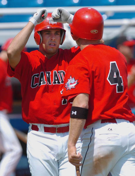 Canadian Adam Stern (L) and Peter Orr celebrate after scoring on Richard Clapp's triple during Olympic baseball against italy during the Athens 2004 Summer Olympic Games August 16, 2004. (CP PHOTO 2004/Andre Forget/COC)