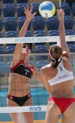 Guylaine Dumont of St-Antoine-de-Tilly, Que. gets ready to hit the ball as Annie Martin of Sherbrooke, Que., (facing the camera) watches her during a beach volleyball game at the Olympic Games in Athens, Saturday, August 14, 2004. (CP PHOTO/COC-Mike Ridewood)