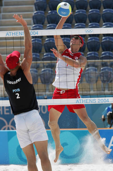Mark Heese of Toronto,right, goes up for the ball against Patrick Heuscher of Switzerland in Canada's loss in beach volleyball at the Athens Olympics, Saturday, August 14, 2004.  (CP PHOTO/COC-Mike Ridewood)