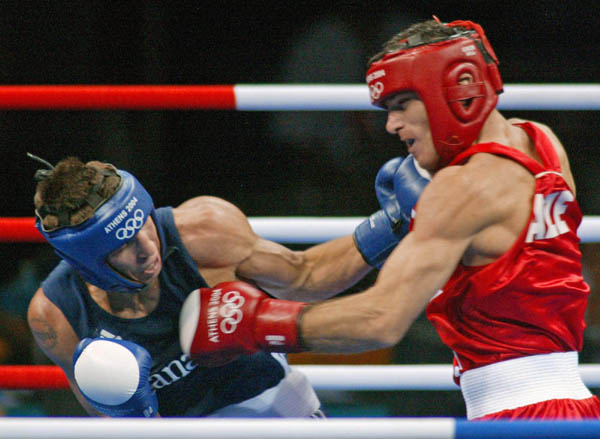 Adam Trupish (right) of Windsor, Ont. lands a punch of Ruslan Khairov of Azerbiajan at the Athens Olympics, Sunday, August 15, 2004. Trupish lost the bout due to an injury.  (CP PHOTO/COC-Mike Ridewood)
