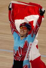 Canada's Lori-Ann Muenzer from Edmonton celebrates e=with the Canadian flag after winning the gold medal in the women's sprint against Russia's Tamilla Abassova at the 2004 Summer Olympic Games in Athens, Greece, Tuesday,  August 24, 2004. (CP PHOTO/COC/Andre Forget)