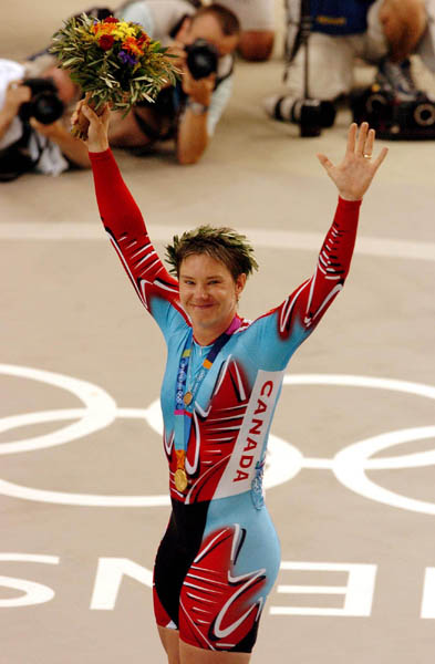 Canada's Lori-Ann Muenzer from Edmonton celebrates on the podium after winning the gold medal in women's sprint cycling at the 2004 Summer Olympic Games in Athens, Greece, Tuesday,  August 24, 2004. (CP PHOTO/COC/Andre Forget)