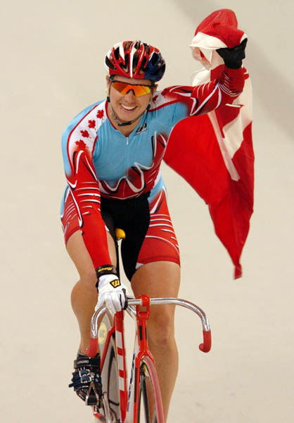 Canada's Lori-Ann Muenzer from Edmonton celebrates with the Canadian flag after winning the gold medal in women's sprint cycling over Russia's Tamilla Abassova at the 2004 Summer Olympic Games in Athens, Greece, Tuesday,  August 24, 2004. (CP PHOTO/COC/Andre Forget)