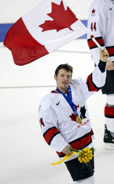 Canada's Theoren Fleury waves the flag after the men's hockey team defeated the U.S. 5 - 2 to take the gold medal at the 2002 Olympic Winter Games in Salt Lake City, Utah, Sun., Feb. 24, 2002 . (CP PHOTO/COA/Mike Ridewood).