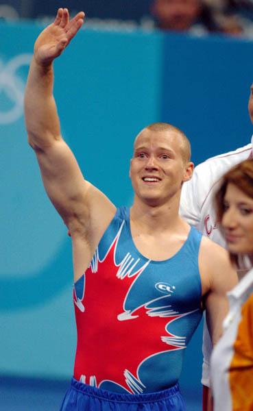Kyle Shewfelt (left) of Calgary waves to the crowd after winning the gold medal for artistic gymnastics in the men's floor exercise during the 2004 Summer Olympic Games in Athens, Greece, Sunday, Aug.22, 2004. (CP PHOTOCOC//Andre Forget)