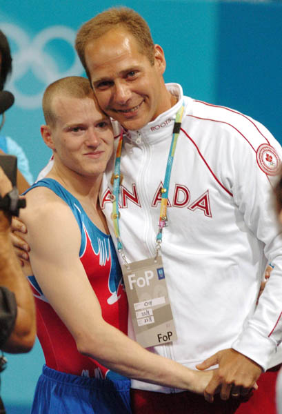 Kyle Shewfelt (left) of Calgary hugs his coach Kelly Manjak after winning the gold medal for artistic gymnastics in the men's floor exercise during the 2004 Summer Olympic Games in Athens, Greece, Sunday, Aug.22, 2004. (CP PHOTOCOC//Andre Forget)