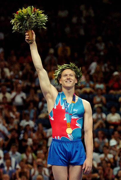 Kyle Shewfelt (left) of Calgary salutes the crowd after winning the gold medal for artistic gymnastics in the men's floor exercise during the 2004 Summer Olympic Games in Athens, Greece, Sunday, Aug.22, 2004. (CP PHOTOCOC//Andre Forget)