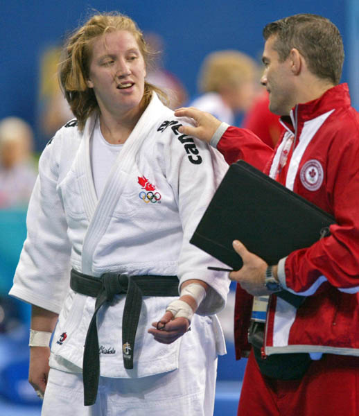 Amy Cotton (left) of Varennes, Que., talks with her coach Ewan Beaton of Montreal after losing to Italy's Lucia Morico during their second round  -78kg judo competition at the Summer Olympics in Athens Thursday, August 19, 2004. Lucia won the match.  (CP PHOTO/COC-Mike Ridewood)