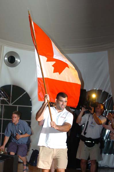 Canadian flagbearer Nicolas Gill presents the flag at the team reception on August 11, 2004 in Athens. (CP PHOTO)2004(COC-Andr Forget)
