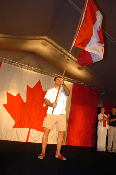 Canadian flagbearer Nicolas Gill waves the flag at the team reception on August 11, 2004 in Athens. (CP PHOTO)2004(COC-Andr Forget)