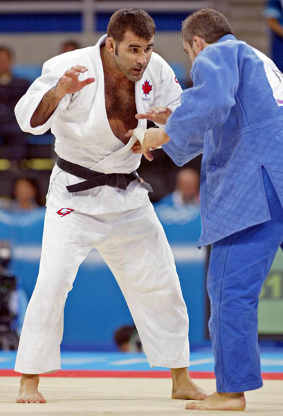 Canada's Nicolas Gill, (left) from Montreal, battles with Italy's Michele Monti in the -100kg judo competition at the Summer Olympics in Athens Thursday, August 19, 2004. Gill, Canada's flag bearer and medal hopefull, lost the first round match. (CP PHOTO/COC-Mike Ridewood)