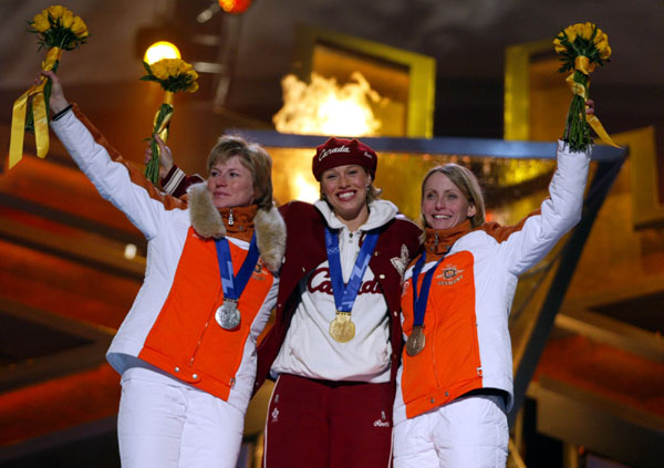 Catriona Le May Doan (centre) of Saskatoon celebrates her gold medal run in the women's 500 metre speed skating event with silver medallist Monique Garbrecht-Enfeldt and bronze medal winner Sabine Voelker (right), both of Germany at the 2002 Olympic Winter Games in Salt Lake City (CP Photo/COA/Andr Forget).