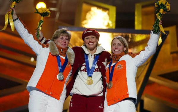 Catriona Le May Doan (centre) of Saskatoon celebrates her gold medal run in the women's 500 metre speed skating event with silver medallist Monique Garbrecht-Enfeldt and bronze medal winner Sabine Voelker (right), both of Germany at the 2002 Olympic Winter Games in Salt Lake City (CP Photo/COA/Andr Forget).