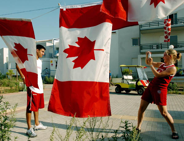 La pongiste Marie-Christine Roussy prend son coquipier Faazil Rassam en photo devant les appartements du Canada au Village olympique le lundi 9 aot 2004.(CP PHOTO 2004/Andre Forget/COC)