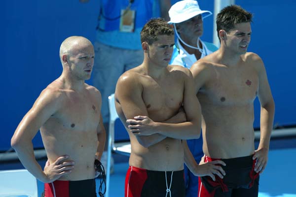 From left to right, Canada's Brian Johns, Andrew Hurd and Mark Johnston await the return of Rick Say.  Canada's 4x200m freestyle relay team finished fifth on August 17, 2004 at the Olympic Games in Athens.  (CP PHOTO)2004(COC-Mike Ridewood)