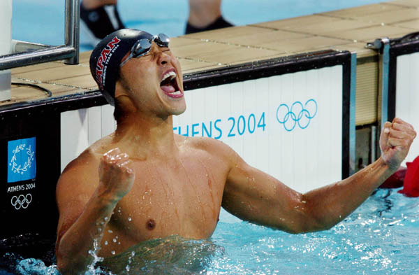 Kosuke Kitajima celebrates his Mens 100M Breaststroke final win during the Athens 2004 Summer Olympic Games Sunday, August 15, 2004. (CP PHOTO/COC-Andre Forget)