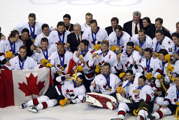Team Canada captain Mario Lemieux and goalie Martin Brodeur are surrounded by teammates as they pose for a team photo after they won over Team USA to win the gold medal in hockey Sunday Feb. 24, 2002 at the 2002 Olympic Winter Games in Salt Lake City.  (CP Photo/COA/Mike Ridewood).