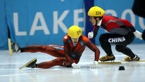 Mathieu Turcotte (319) is taken down by Jiajun Li from China during the Men's 1000 metre Semi Final, Feb. 16, at the 2002 Olympic Winter Games in Salt Lake City. (CP Photo/COA/Andre Forget).