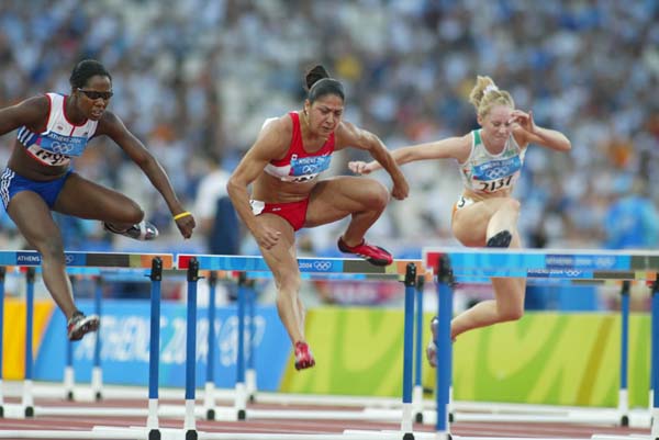 Canada's Priscilla Lopes of Whitby, Ontario, in her heat of women's 100 metre hurdles in track and field action at the Olympic Games in Athens, Sunday, August 22, 2004.(CP PHOTO)2004(COC-Mike Ridewood)