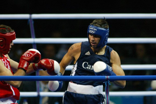 Adam Trupish (right) of Windsor, Ont. fights Ruslan Khairov of Azerbiajan at the Olympic Games in Athens, Sunday, August 15, 2004. Trupish lost the bout due to an injury. (CP PHOTO/COC-Mike Ridewood)