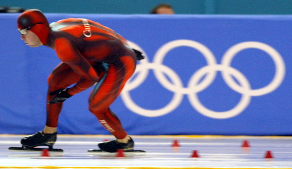 Canadian long-track Speed Skater Eric Brisson speeds past the Olypic rings during the 500 m in Salt Lake City, Utah Tuesday Feb. 12, at the 2002 Olympic Winter Games. (CP Photo/COA/Andre Forget).