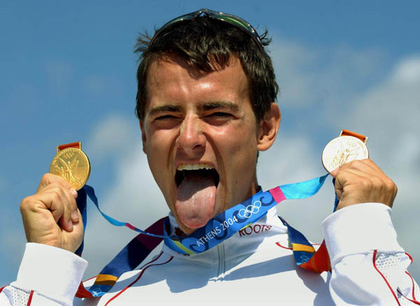 Canada's Adam van Koeverden holds up a gold and bronze medal after competing at the Athens 2004 Summer Olympic Games Saturday, August 28, 2004. van Koeverden won gold following the K1 500m today and the bronze yesterday K1 1000m kayak race. (CP PHOTO/COC-Andre Forget)