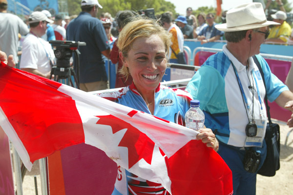 Canada's Marie-Helene Premont of Chateau-Richer, Que. holds a canadian flag after winning the silver medal in women's mountain bike action at the Olympic Games in Athens, Friday, August 27, 2004.(CP PHOTO/COC-Mike Ridewood)