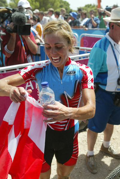 Canada's Marie-Helene Premont of Chateau-Richer, Que. with a Canadian flag after winning the silver medal in women's mountain bike action at the Olympic Games in Athens, Friday, August 27, 2004.(CP PHOTO/COC-Mike Ridewood)