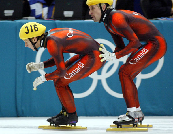 Canadian Short Track Gold skater Marc Gagnon gives a push to teammate Jonathan Guilmette during the Men's 5000 metre Relay Saturday Feb. 23, 2002 at the 2002 Olympic Winter Games in Salt Lake City. The Canadians went on to win gold. (CP Photo/COA/Andre Forget).