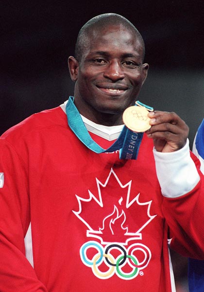 Canada's Daniel Igali shows off the medal he won for wrestling at the Sydney 2000 Olympic Games. (CP PHOTO/ COA)