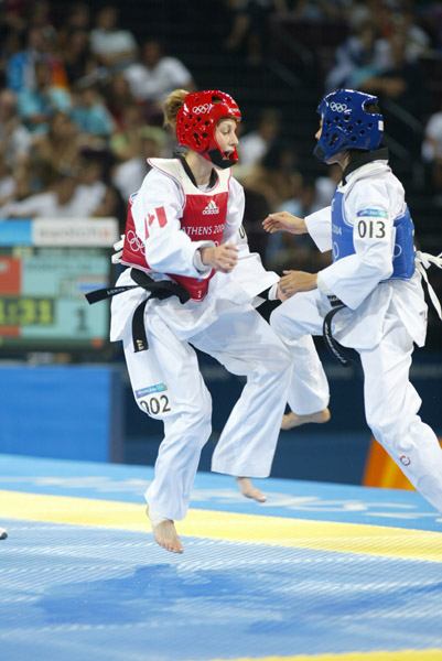 Canada's Ivett Gonda (red) from Port Moody, B.C. competes in the under 49kg taekwondo repechage at the Summer Olympic Games in Athens, Greece on Thursday August 26, 2004. Canada's Gonda was eliminated by Boorapolchai who moved on to compete for the bronze medal. (CP PHOTO/COC/Mike Ridewood)