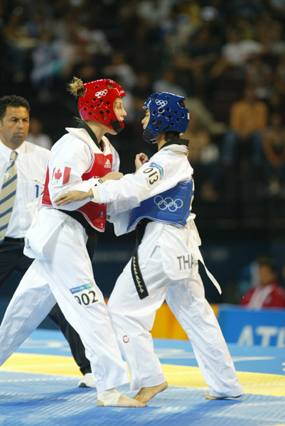 Canada's Ivett Gonda (left) from Port Moody, B.C. competes in the under 49kg taekwondo repechage at the Summer Olympic Games in Athens, Greece on Thursday August 26, 2004. Canada's Gonda was eliminated by Boorapolchai who moved on to compete for the bronze medal. (CP PHOTO/COC/Mike Ridewood)